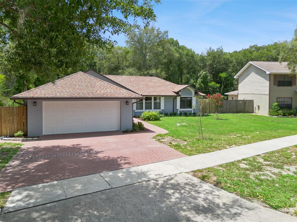 A single-story house with a gray exterior, a two-car garage, and a brick driveway — 125 DONNA CIRCLE, SANFORD, FL