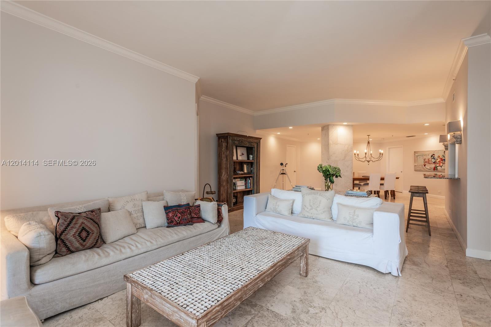 A living room features two sofas, a tiled floor, and a wooden coffee table — 888 Brickell Key Dr # 211, Miami FL 33131, MIAMI, FL