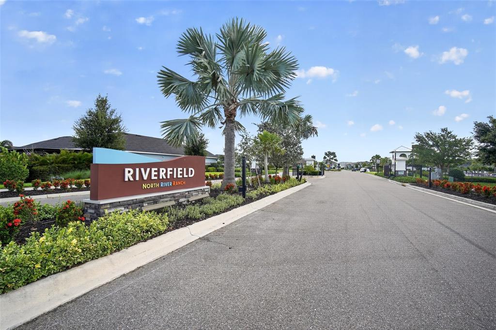 A sign for Riverfield at North River Ranch stands beside a road with landscaping — 8612 ARROW CREEK DRIVE, PARRISH, FL