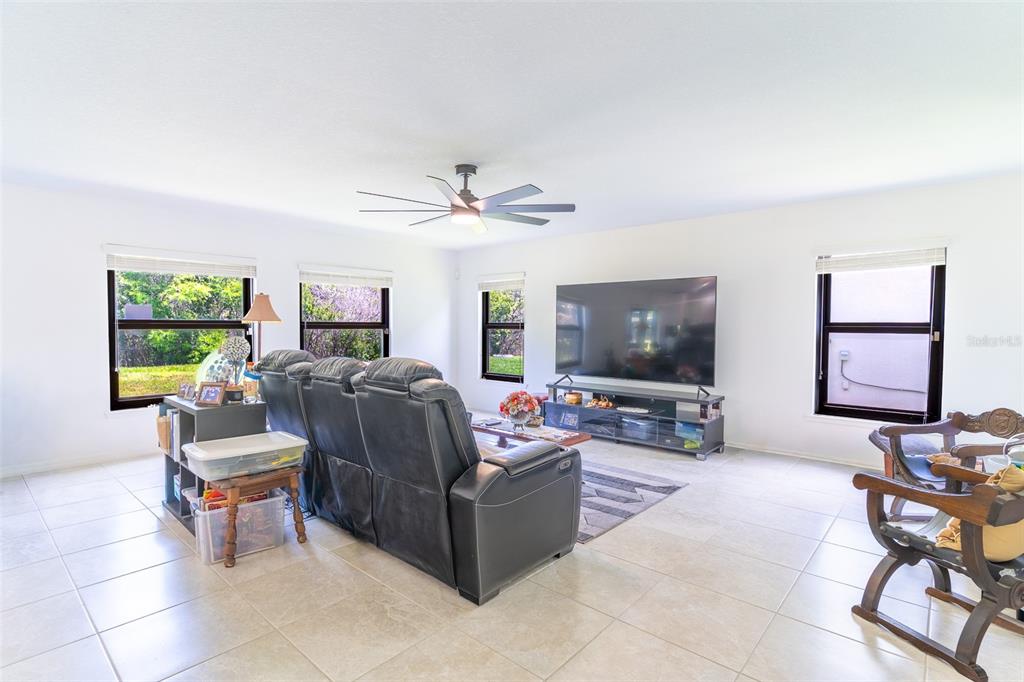 A living room features light tile floors, a large television, and a dark leather sofa — 2926 BOATING BOULEVARD, KISSIMMEE, FL