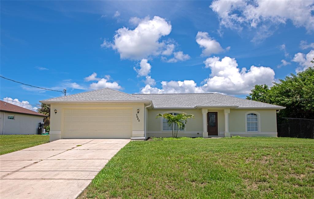 A single-story house with a beige exterior, a two-car garage, and a concrete driveway — 7680 LAMPLIGHTER AVENUE, NORTH PORT, FL