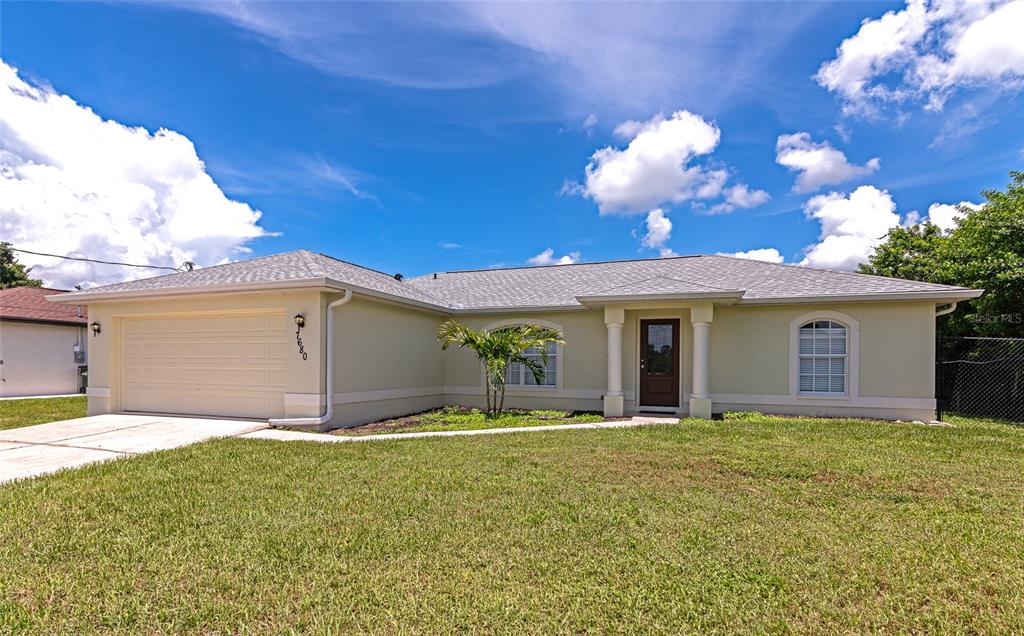 A single-story house with a beige exterior, a two-car garage, and a covered front entryway — 7680 LAMPLIGHTER AVENUE, NORTH PORT, FL