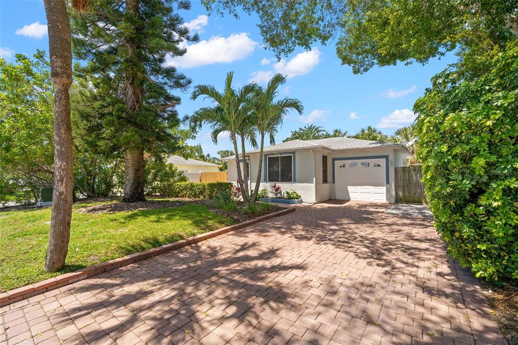 A single-story house with a brick paver driveway, palm trees, and a one-car garage — 517 79TH AVENUE, ST PETE BEACH, FL