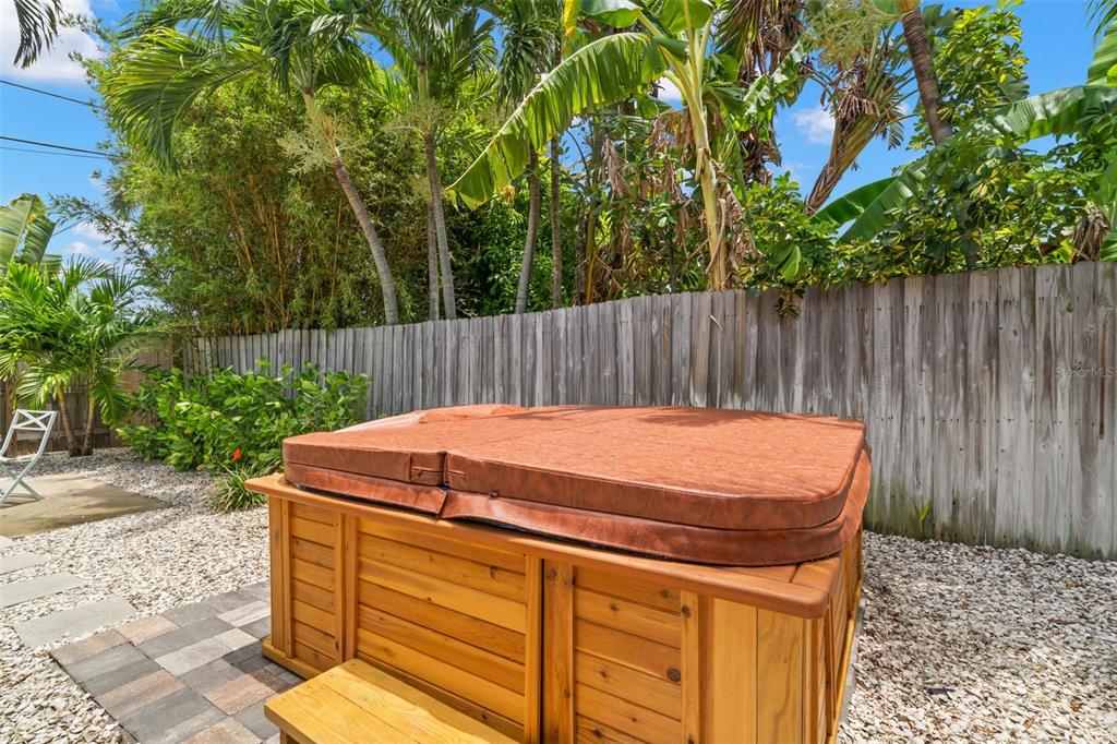 A wooden hot tub with a brown cover sits on a patio in a backyard — 517 79TH AVENUE, ST PETE BEACH, FL
