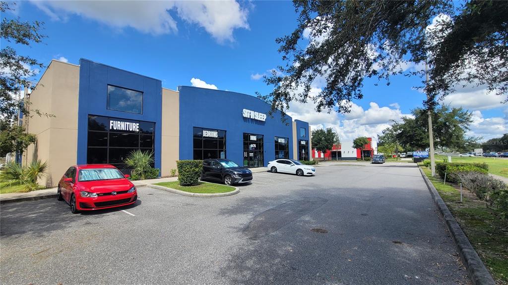 A blue commercial building with a furniture store storefront and a parking lot in front — 4476 PLEASANT HILL ROAD, KISSIMMEE, FL