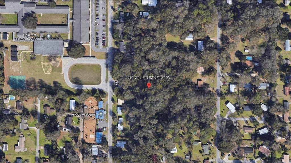 This is an aerial map view showing a wooded lot near a school and daycare — NE 13TH AVE, OCALA, FL