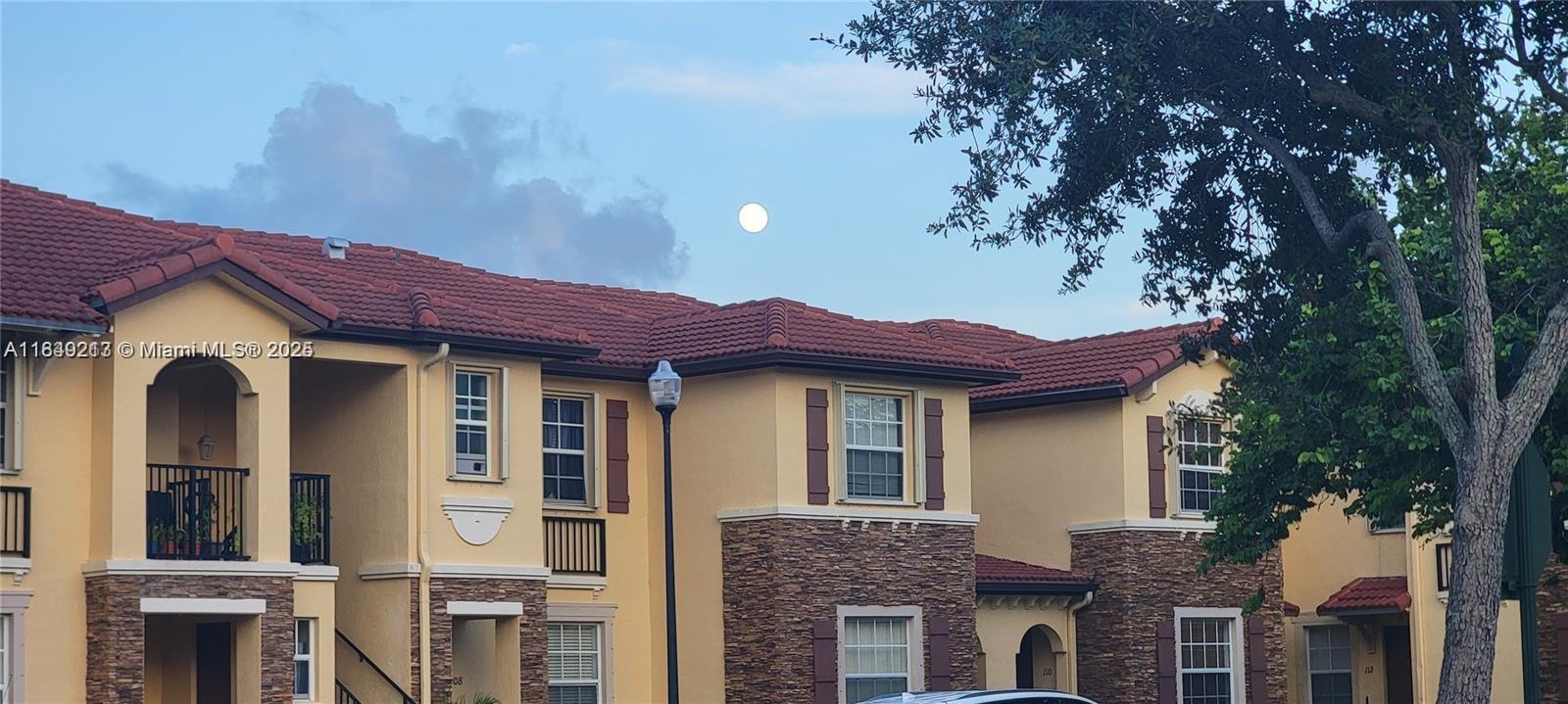 A multi-story residential building features tan stucco walls, stone veneer accents, and red tile roofs — 1655 NE 33rd Rd # 4, Homestead FL 33033, HOMESTEAD, FL
