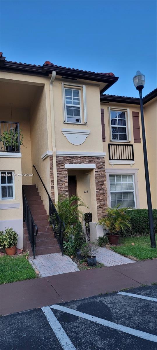 A two-story residential building exterior features a stone-accented entrance, a staircase, and a balcony — 1655 NE 33rd Rd # 4, Homestead FL 33033, HOMESTEAD, FL