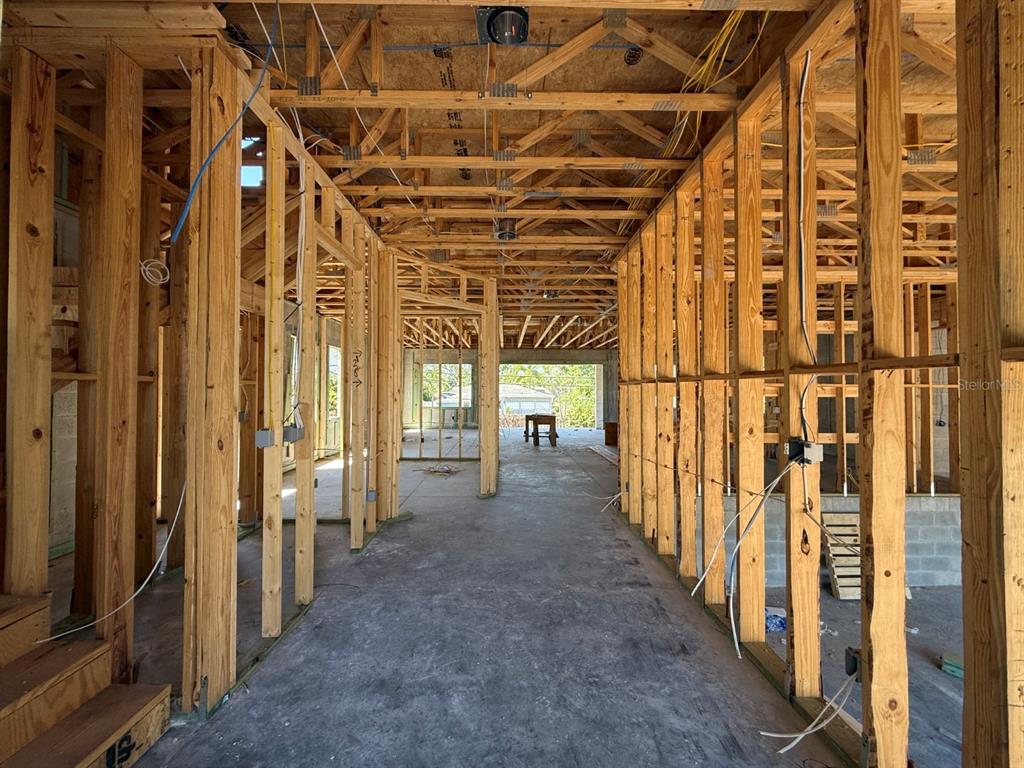 An interior view of a house under construction showing wood framing and exposed ceiling trusses — 4703 W FAIR OAKS AVENUE, TAMPA, FL