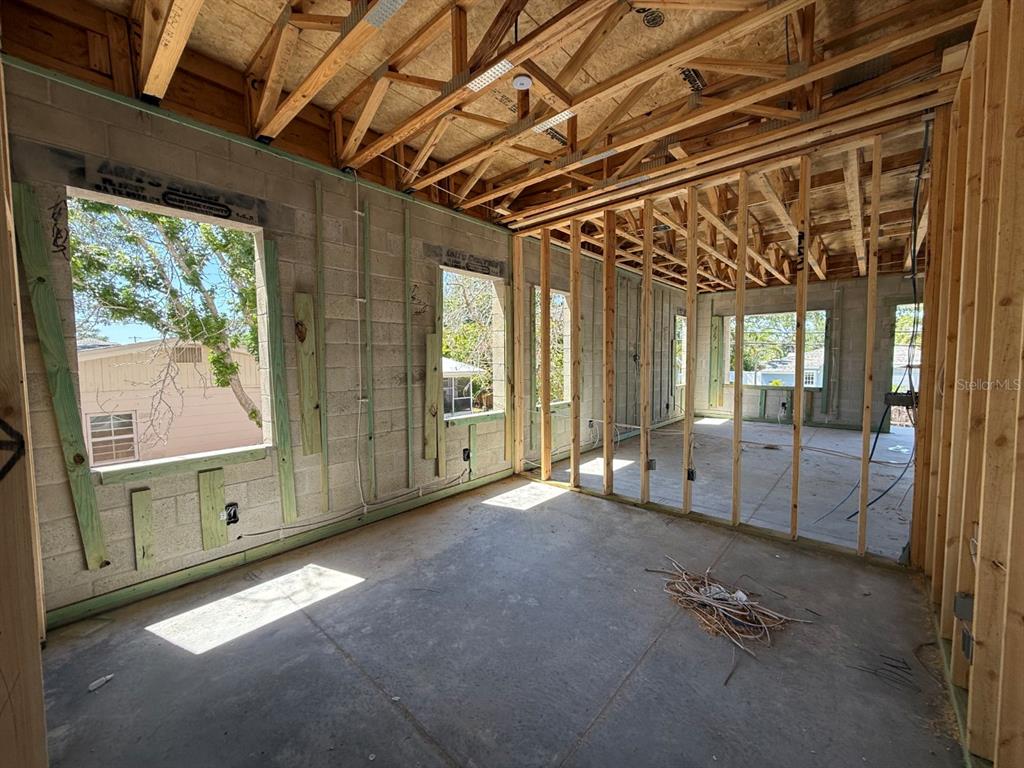 An unfinished room under construction features concrete block walls, exposed wood framing, and large window openings — 4703 W FAIR OAKS AVENUE, TAMPA, FL