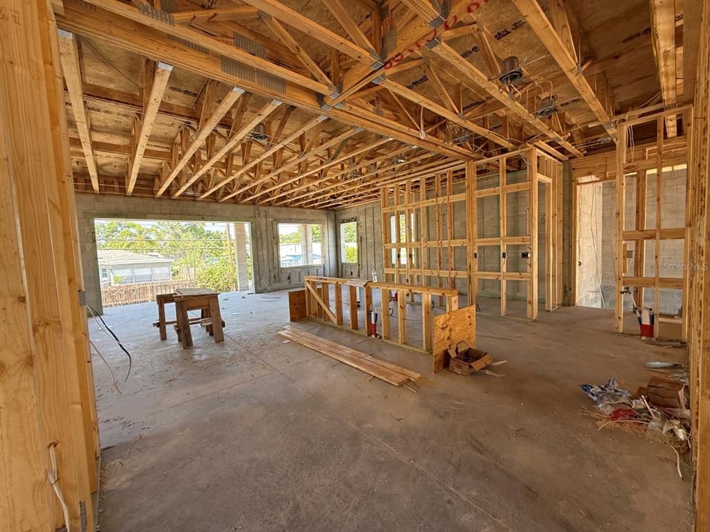 An interior view of a house under construction with exposed wooden framing and concrete floors — 4703 W FAIR OAKS AVENUE, TAMPA, FL