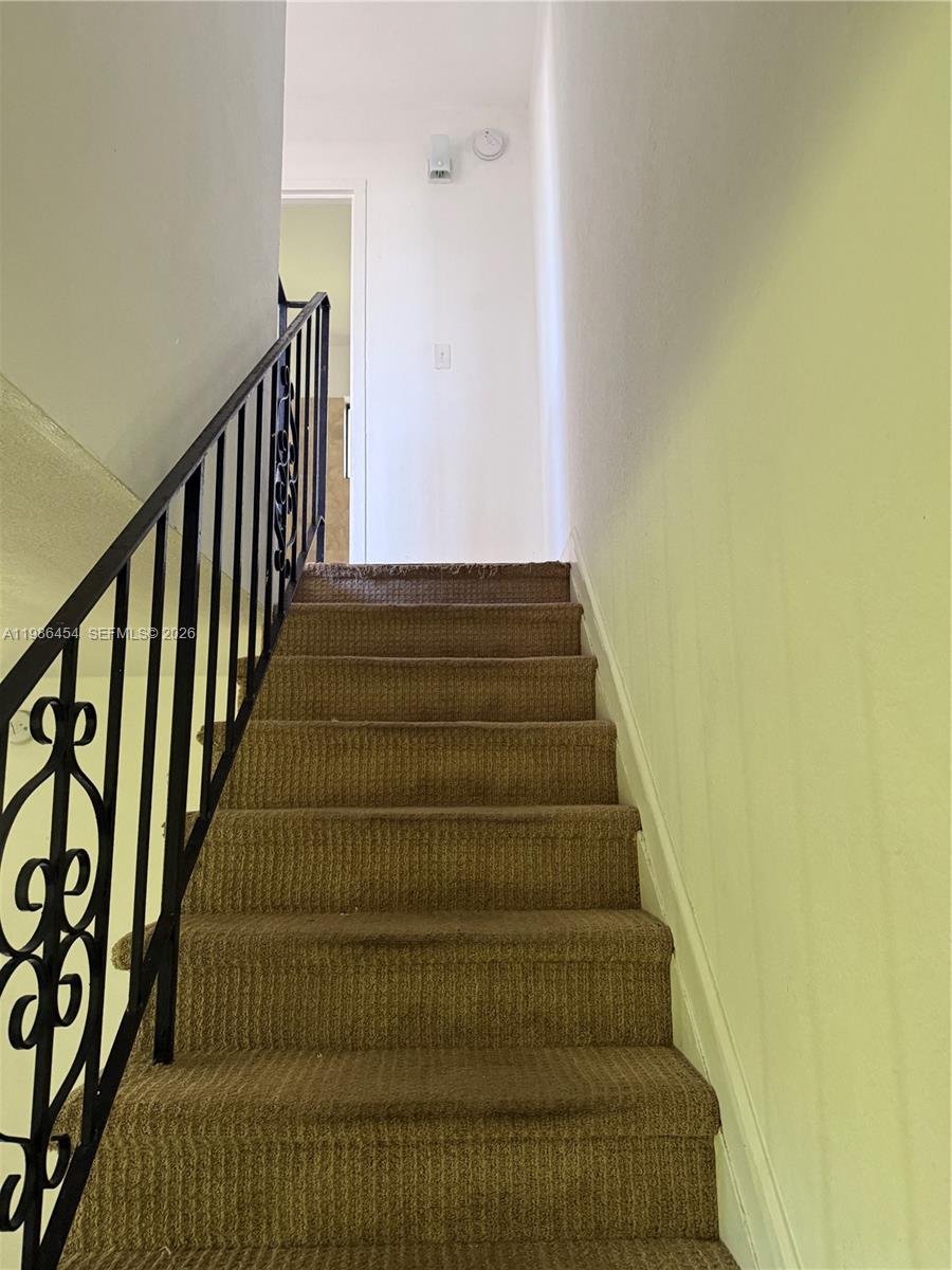 A kitchen features white appliances, wood-look cabinets, and a granite countertop — 180 NE 71st St # 3, Miami FL 33138, MIAMI, FL