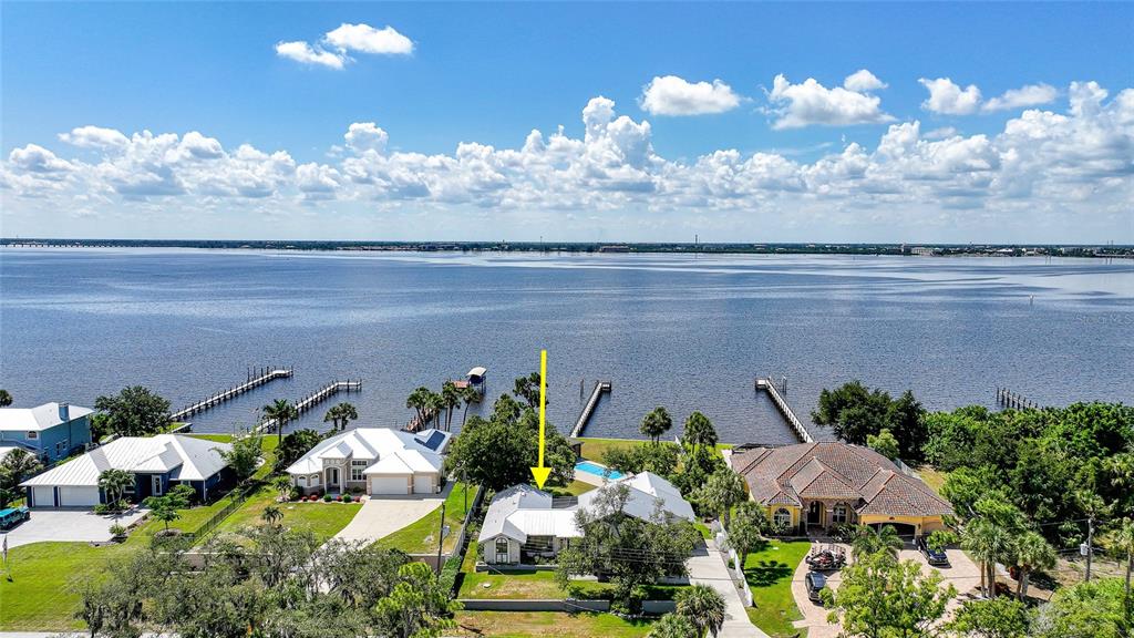 An aerial view shows a waterfront house with a yellow arrow pointing to its roof — 4460 NORTHSHORE DRIVE, PUNTA GORDA, FL