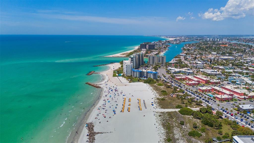 An aerial view of a sandy beach, turquoise ocean, and coastal buildings in Florida — 680 71ST AVENUE UNIT 11-A, ST PETE BEACH, FL