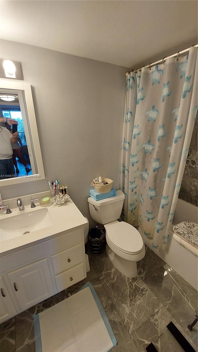 A bathroom features a white vanity, a toilet, and a shower curtain with turtle patterns — 501 E Three Islands Blvd # 417, Hallandale Beach FL 33009, HALLANDALE BEACH, FL