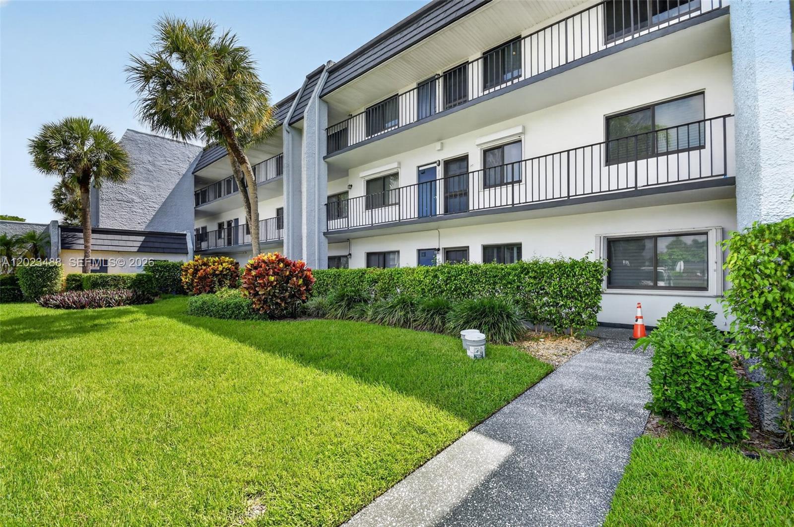 An open blue door leads from an outdoor walkway into a tiled apartment entryway — 4230 Deste Ct # 107, Lake Worth FL 33467, LAKE WORTH, FL