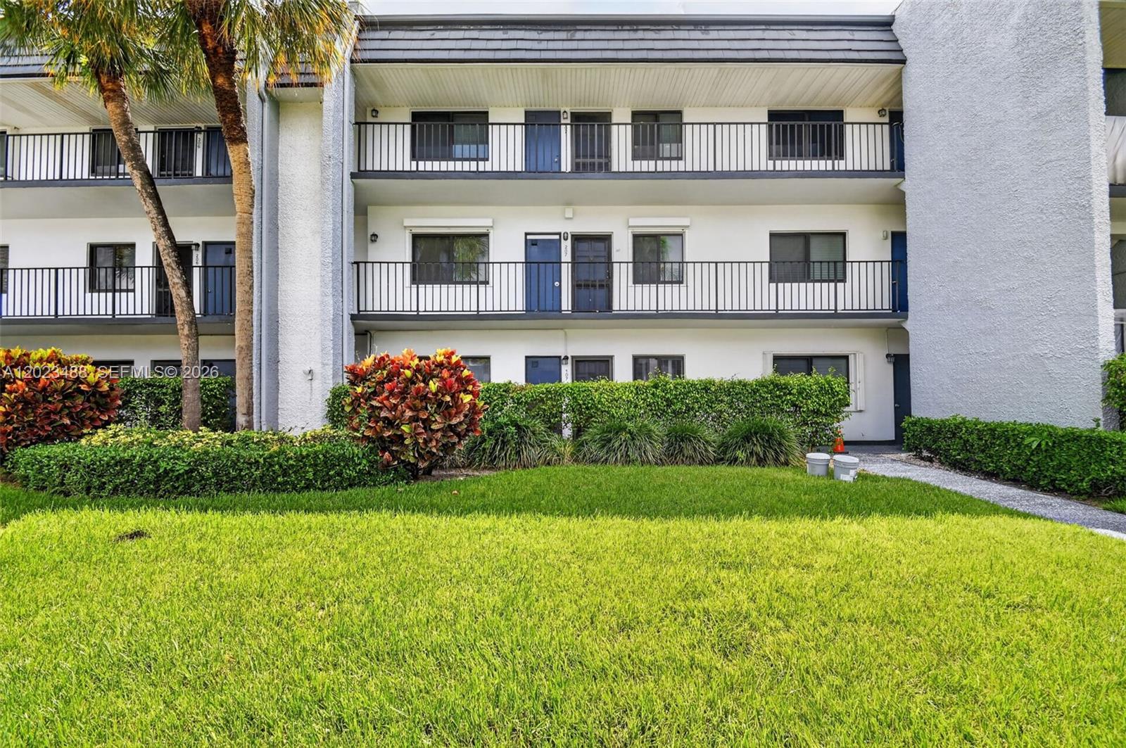 A tiled entryway leads to a living area with mirrored walls and louvered closet doors — 4230 Deste Ct # 107, Lake Worth FL 33467, LAKE WORTH, FL