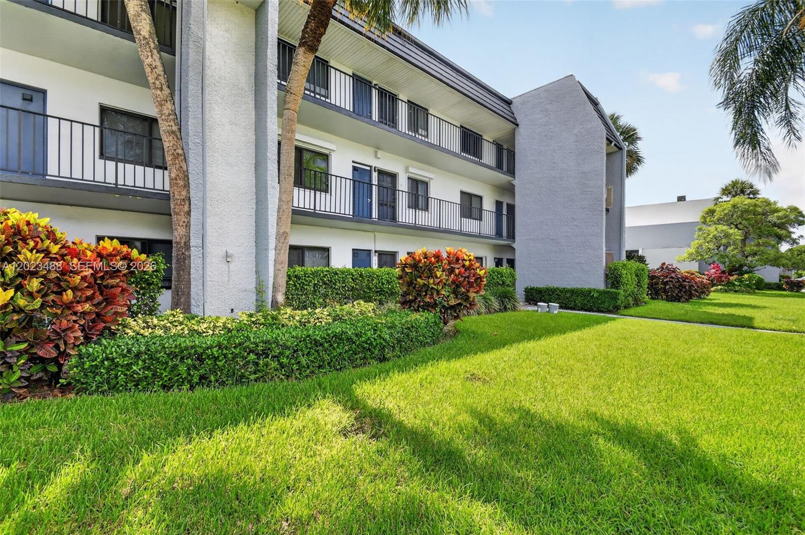 An empty room features white tile flooring, mirrored walls, and a textured ceiling — 4230 Deste Ct # 107, Lake Worth FL 33467, LAKE WORTH, FL