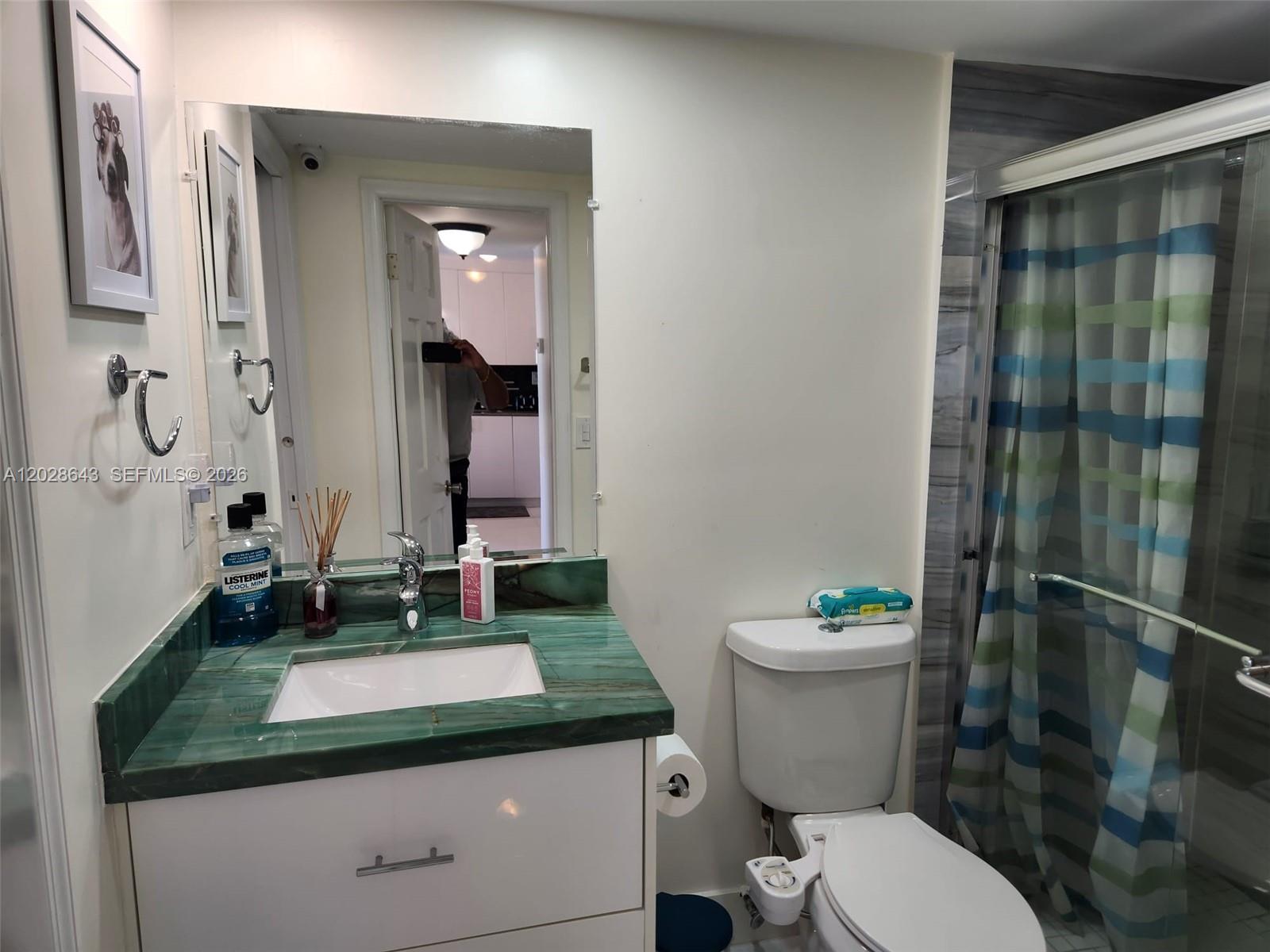 A bathroom features a green stone vanity countertop, white cabinetry, and a walk-in shower — 345 Ocean Dr # 602, Miami Beach FL 33139, MIAMI BEACH, FL