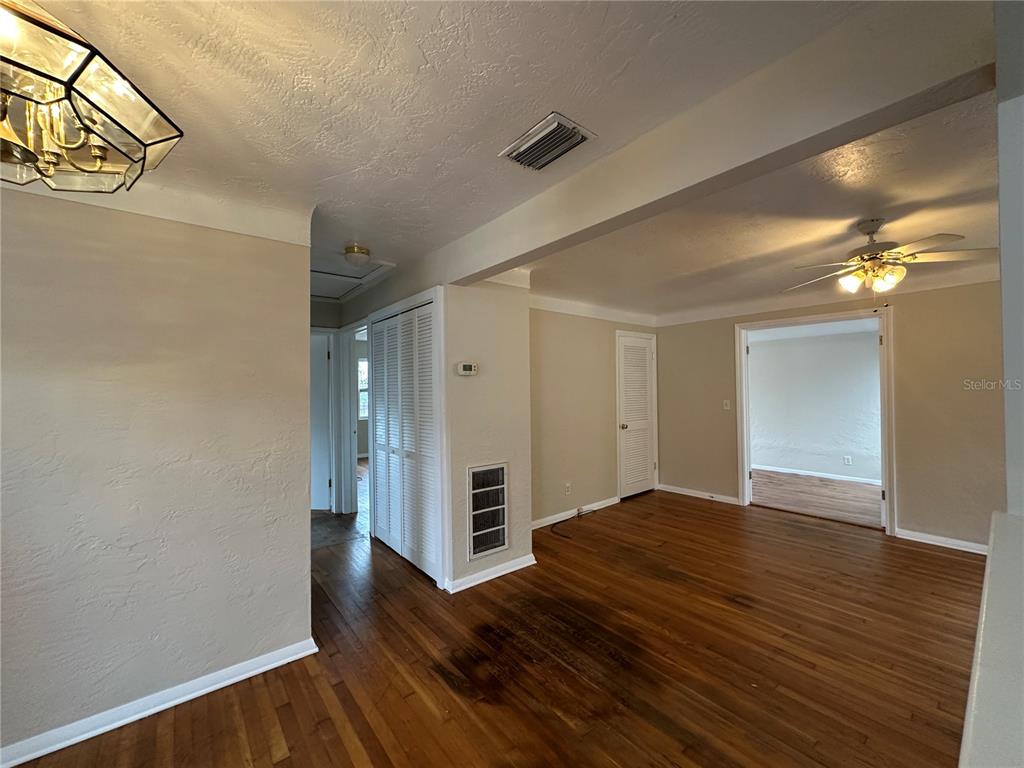 An interior view of a room with hardwood floors, a ceiling fan, and white doors — 4526 6TH AVENUE N, ST PETERSBURG, FL