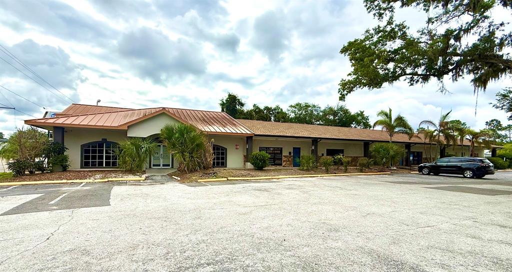 A single-story commercial building with a metal roof and a large paved parking lot — 4211 E BUSCH BOULEVARD UNIT A, TAMPA, FL