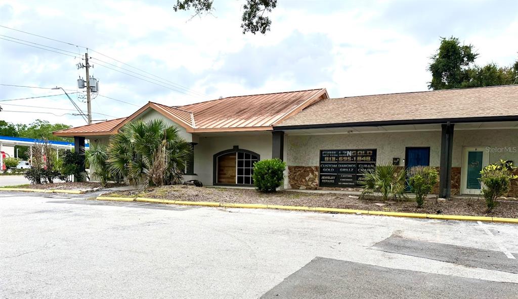 A commercial building with a metal roof and a jewelry store sign in the parking lot — 4211 E BUSCH BOULEVARD UNIT A, TAMPA, FL