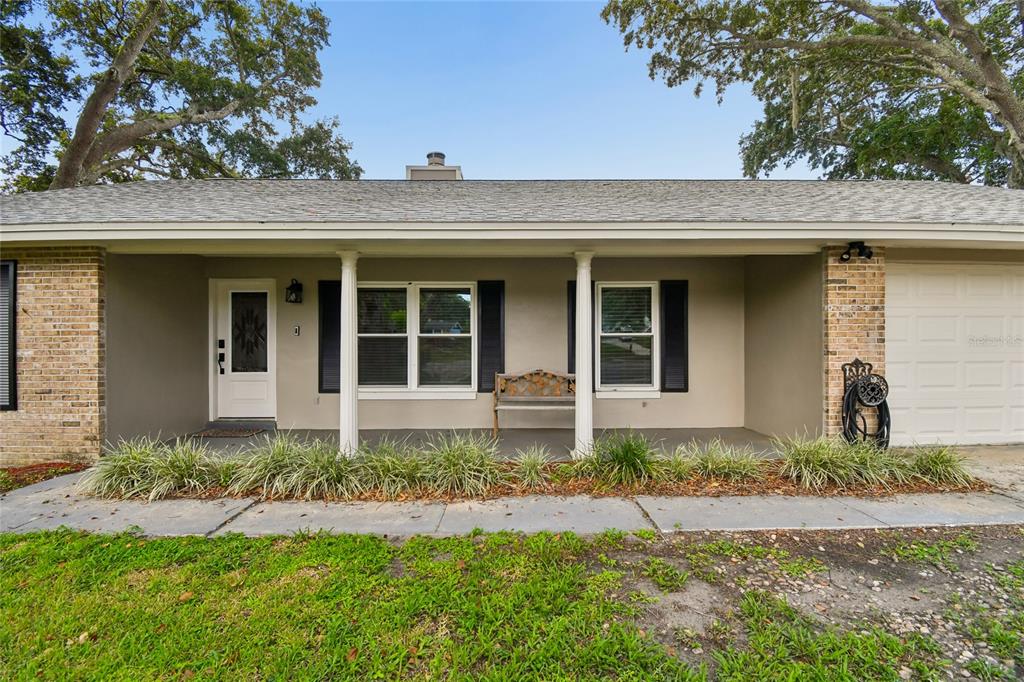 The exterior of a single-story house features a covered porch, brick accents, and a garage — 3244 HUNTER COURT, APOPKA, FL