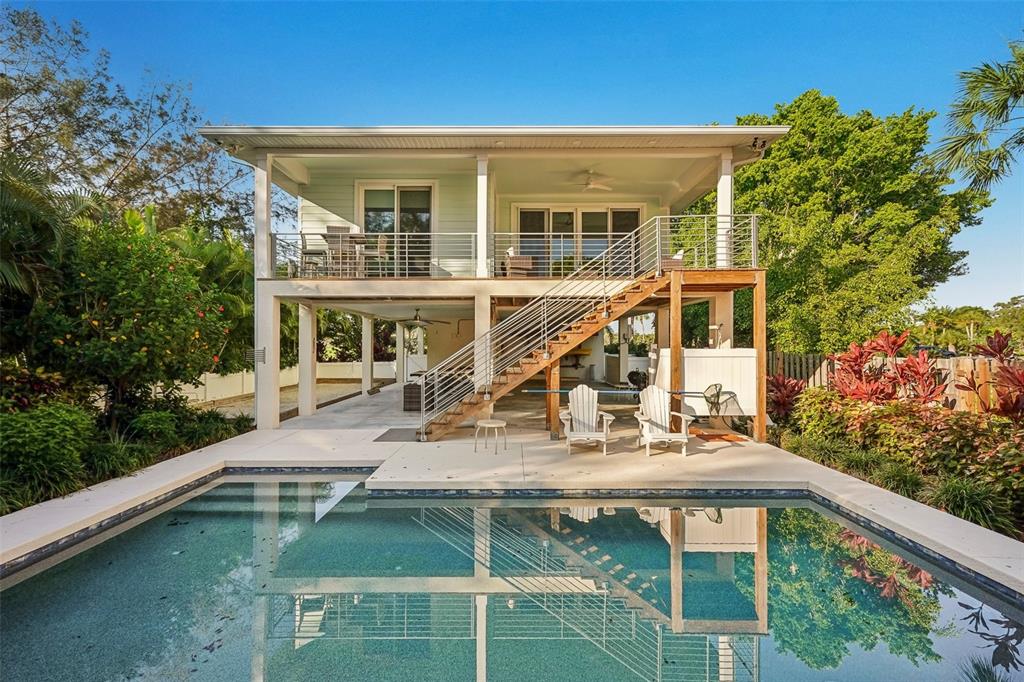 A two-story elevated house with a swimming pool, patio, and outdoor staircase — 501 CHANNEL LANE, LONGBOAT KEY, FL