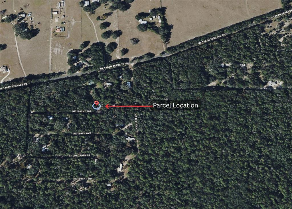 This is an aerial map showing a parcel location marked with a red pin and arrow — TBD NW 138TH TERRACE, FORT MC COY, FL