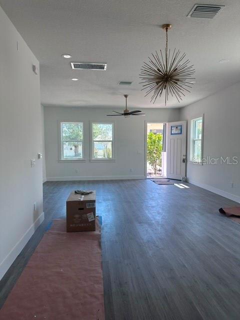 This living area features light gray flooring, a sunburst chandelier, and a ceiling fan — 1531 29TH AVENUE N, ST PETERSBURG, FL