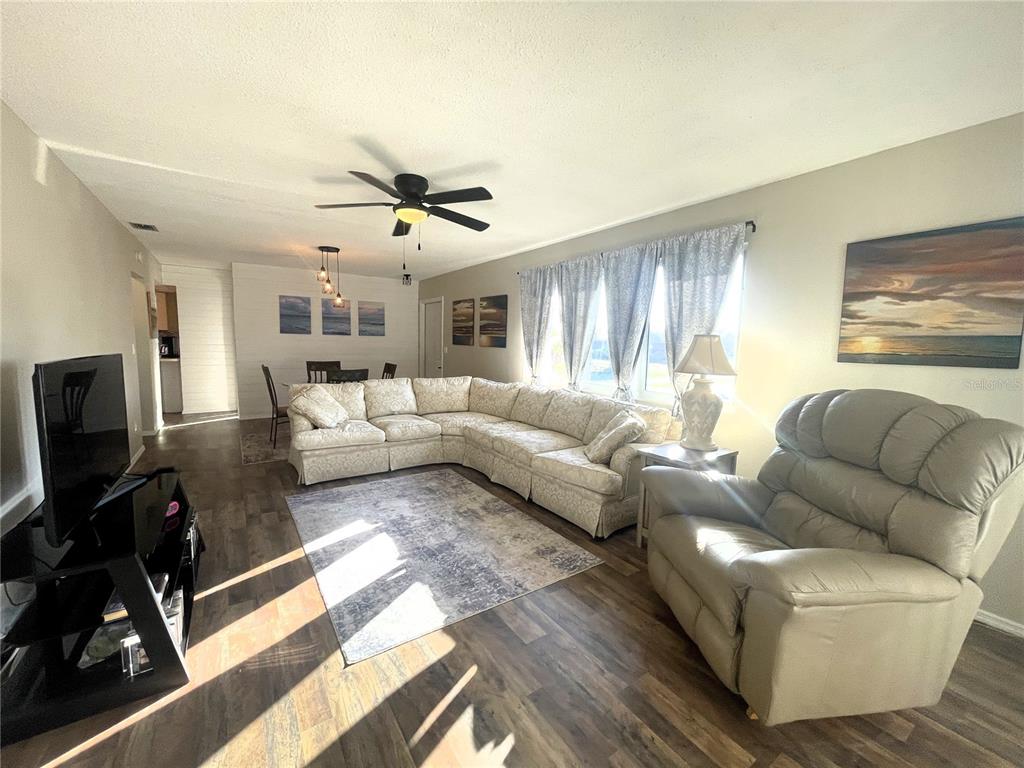 A living room features a large sectional sofa, a recliner, and wood-look flooring — 200 ROTONDA BOULEVARD W UNIT A4, ROTONDA WEST, FL