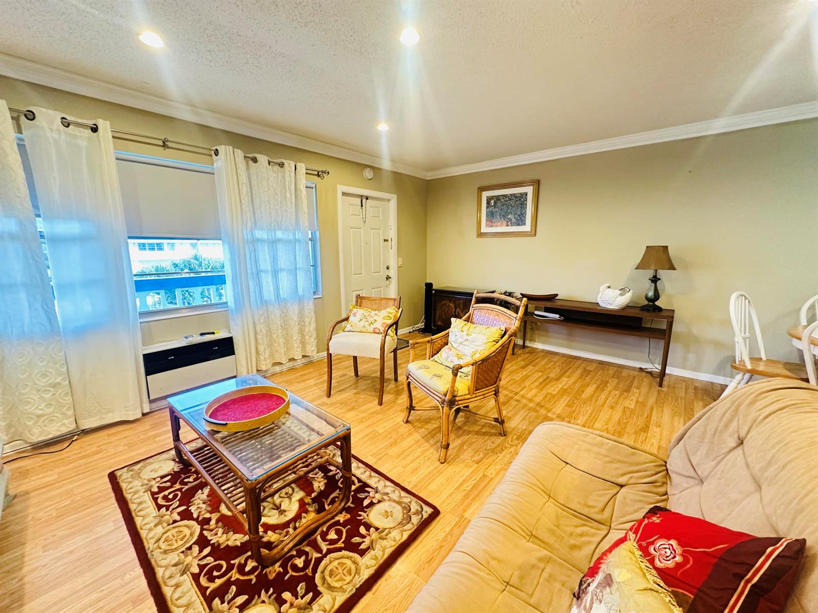 A living room features light wood flooring, a glass-topped coffee table, and two rattan chairs — 238 Newport O # 238, Deerfield Beach FL 33442, DEERFIELD BEACH, FL