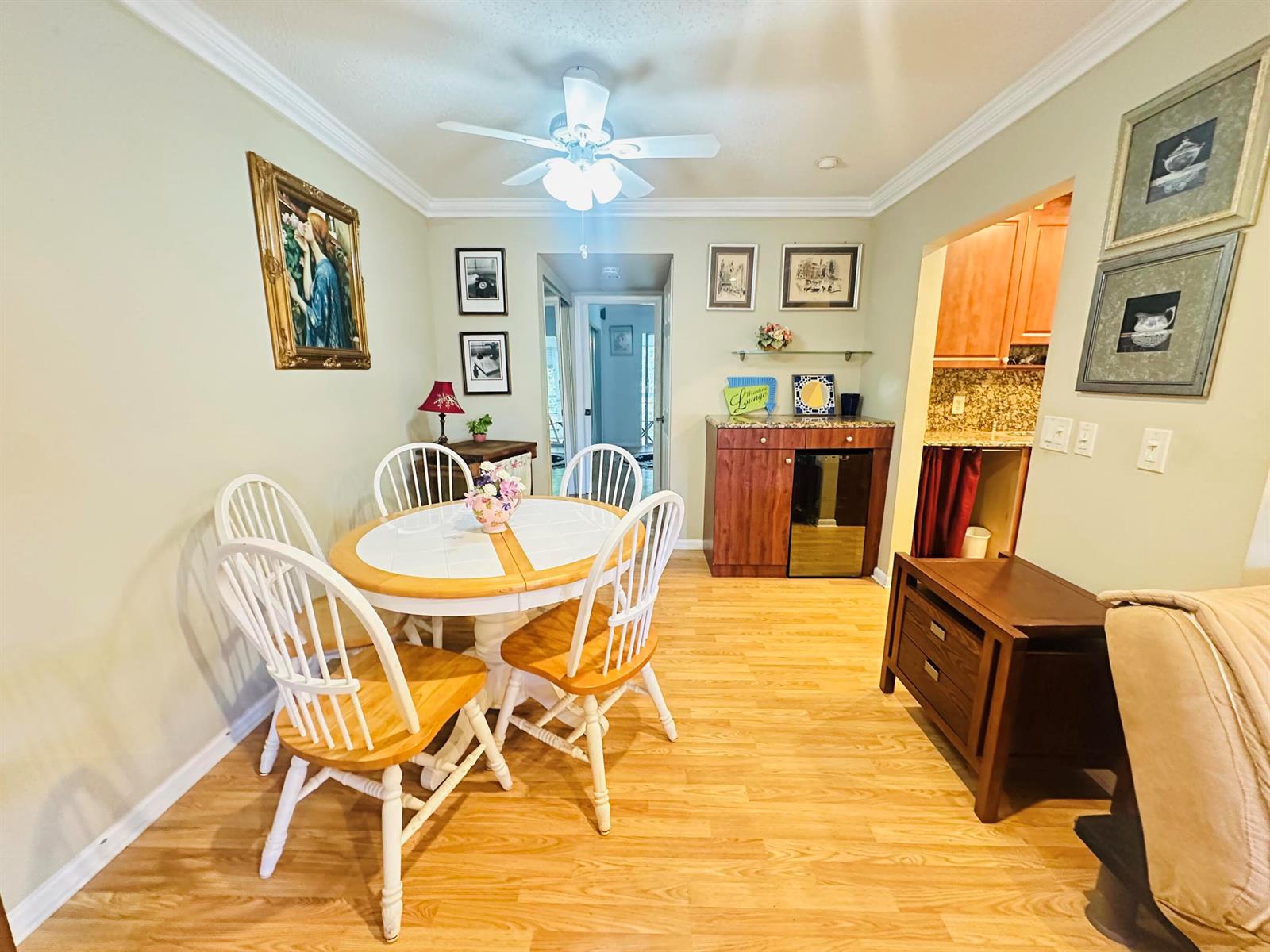 A dining area features a round table with four chairs, wood flooring, and a wet bar — 238 Newport O # 238, Deerfield Beach FL 33442, DEERFIELD BEACH, FL