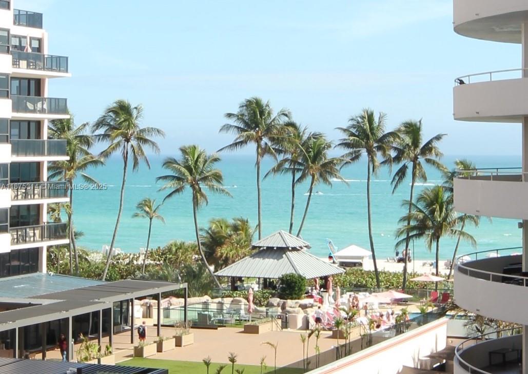 An elevated view of a beach resort with palm trees, a pool area, and ocean — 5161 Collins Ave # 603, Miami Beach FL 33140, MIAMI BEACH, FL