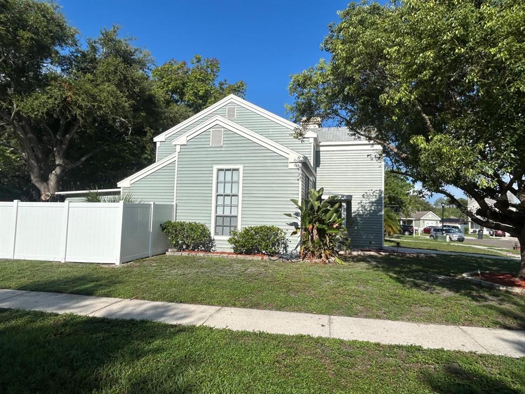 A light green two-story house with white trim and a white vinyl privacy fence — 5102 PEACHGREEN COURT, TAMPA, FL