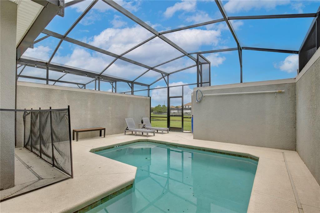 A screened-in patio features a swimming pool, lounge chairs, and a concrete deck — 3062 GATSBY STREET, KISSIMMEE, FL