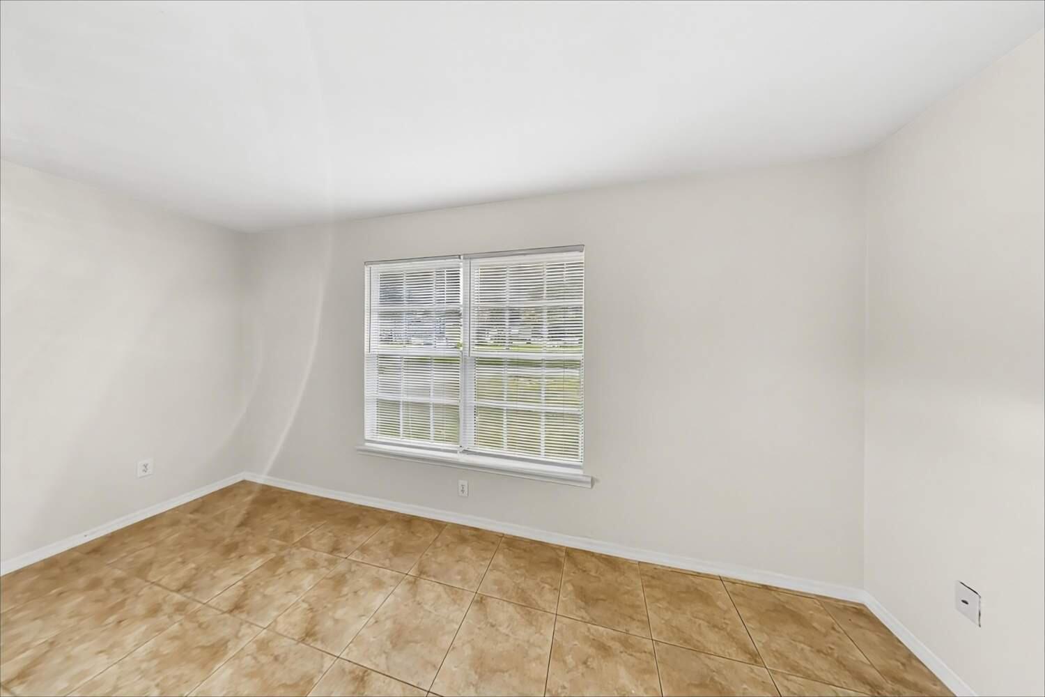 An empty room with light-colored walls, tile flooring, and a window with white blinds — NORTH PALM BEACH, FL