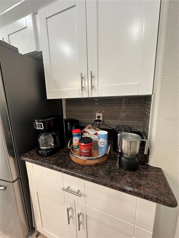A kitchen coffee station features white cabinets, dark granite countertops, and a tiled backsplash — 29651 BIRDS EYE DRIVE, WESLEY CHAPEL, FL