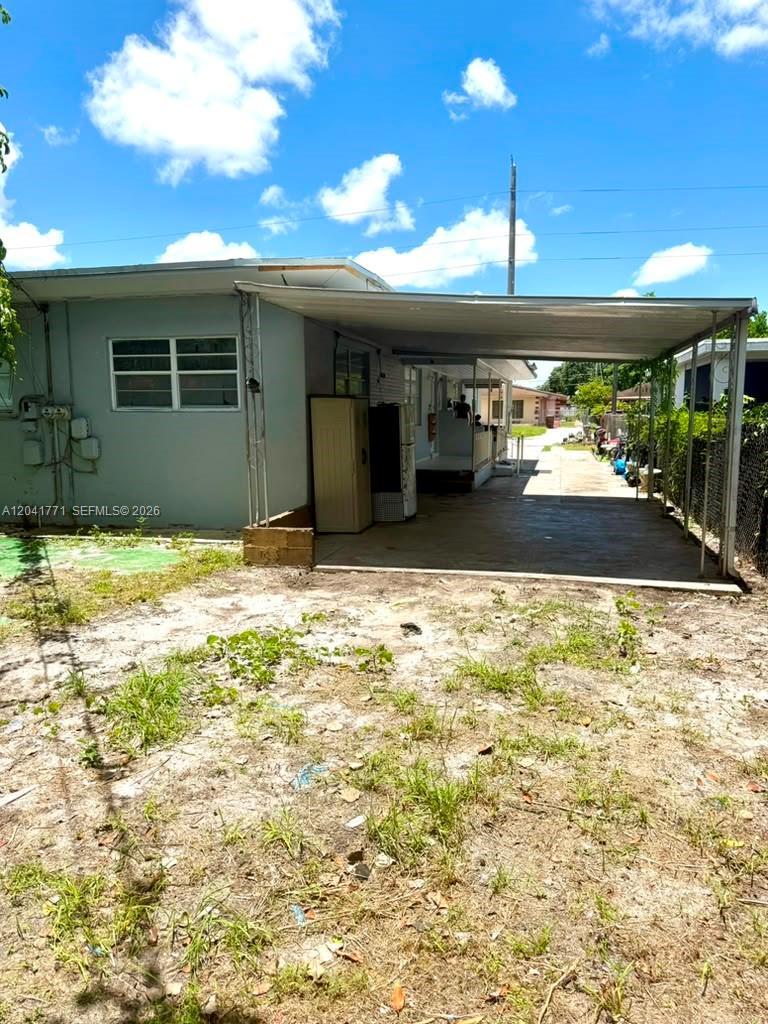 A light blue house features a large metal carport and a sandy, unpaved yard — 42 E 13th St, Hialeah FL 33010, HIALEAH, FL