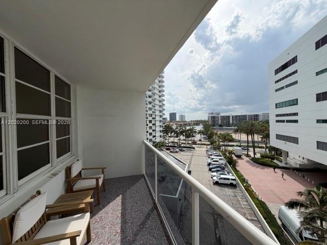 A balcony with wooden chairs overlooks a parking lot and nearby buildings — 3725 S Ocean Dr # 615, Hollywood FL 33019, HOLLYWOOD, FL