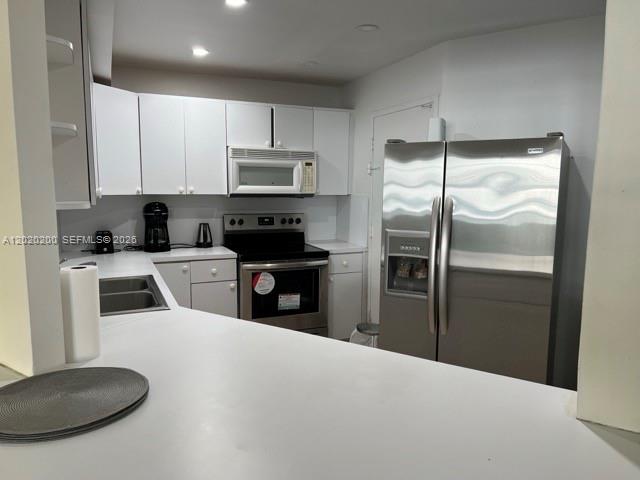 A kitchen features white cabinets, stainless steel appliances, and a white countertop — 3725 S Ocean Dr # 615, Hollywood FL 33019, HOLLYWOOD, FL