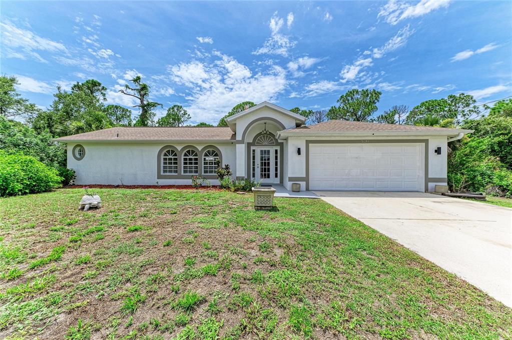 A single-story house with a white stucco exterior, arched entryway, and a two-car garage — 3081 JODY STREET, PORT CHARLOTTE, FL