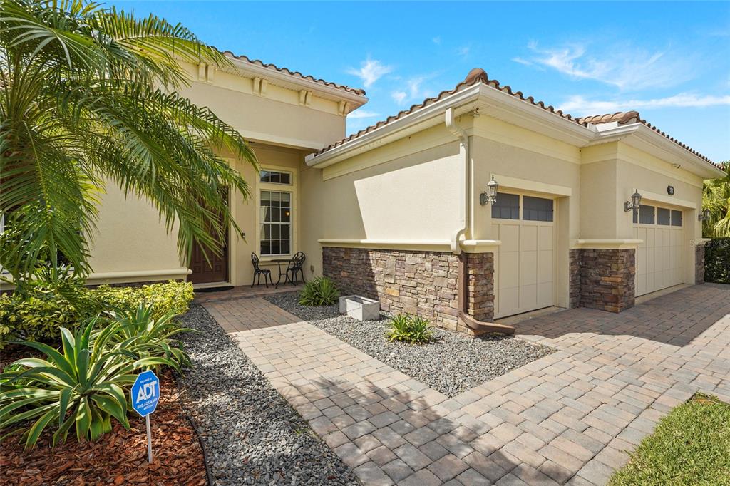 A paved walkway leads to the front entrance and a two-car garage of a house — 5750 ROCK DOVE DRIVE, SARASOTA, FL
