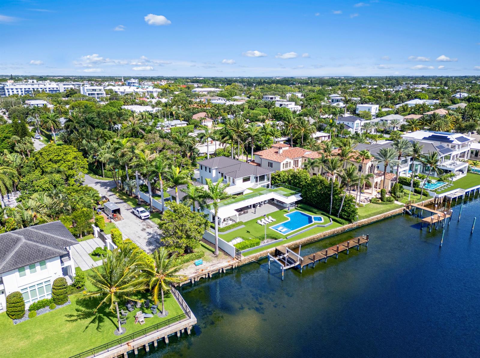 An aerial view shows a waterfront house with a pool, dock, and lush landscaping — 201 Palm Trail, Delray Beach FL 33483, DELRAY BEACH, FL