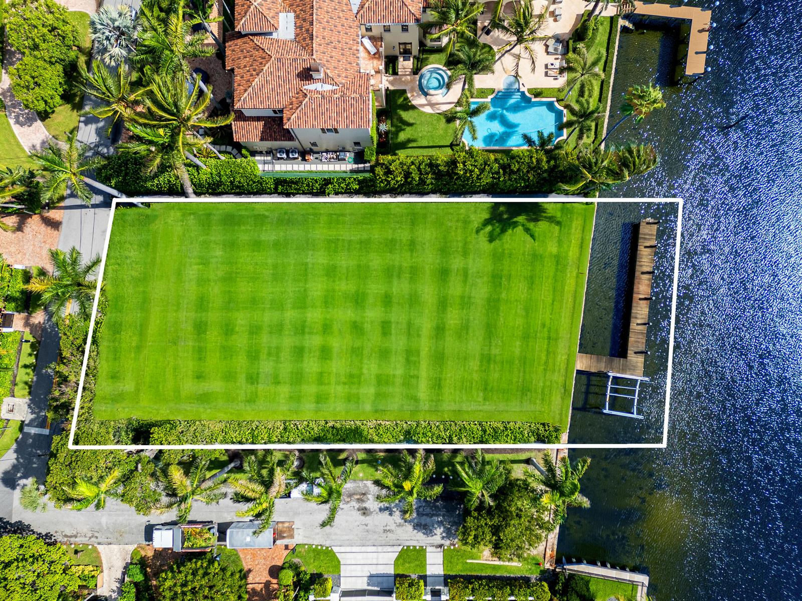 An aerial view shows a large, rectangular grassy lot bordering a canal with a dock — 201 Palm Trail, Delray Beach FL 33483, DELRAY BEACH, FL