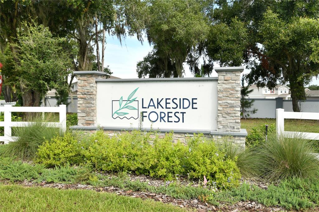 A stone and white monument sign for Lakeside Forest stands in a landscaped residential area — 4235 SAWTOOTH COURT, TAVARES, FL
