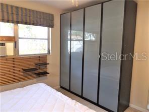 A bedroom features a large wardrobe with frosted glass doors and a slatted wood wall — 3621 MCINTOSH ROAD, SARASOTA, FL