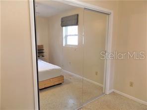 A bedroom features a bed and a large sliding mirrored closet door — 3621 MCINTOSH ROAD, SARASOTA, FL