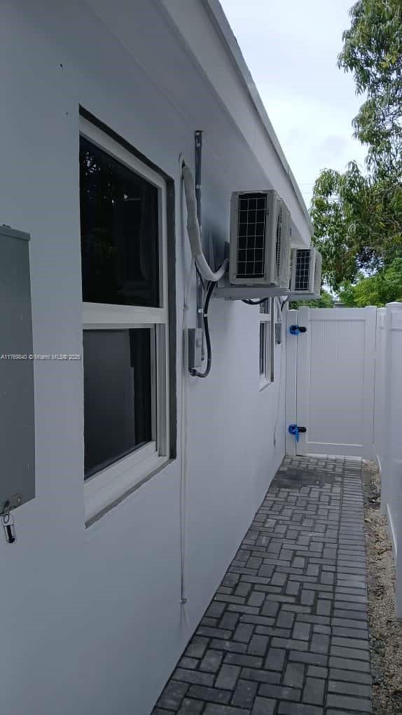 The exterior side of a white building features two wall-mounted air conditioning units and pavers — 5636 Arthur St, Hollywood FL 33021, HOLLYWOOD, FL