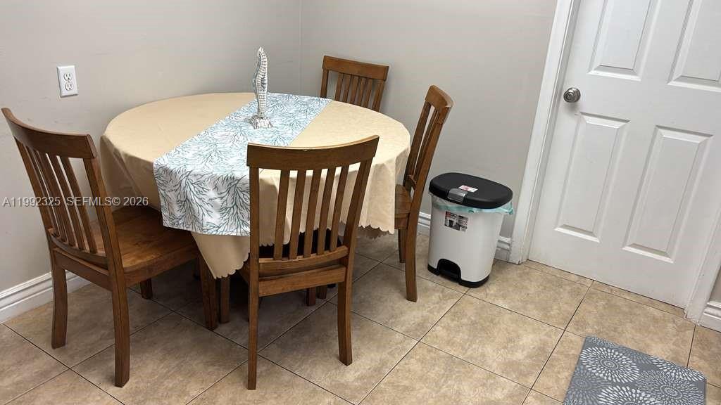 A round dining table with four wooden chairs sits on a tiled floor — 1120 NE 24th Ave # 2, Pompano Beach FL 33062, POMPANO BEACH, FL